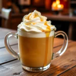 A cozy mug of homemade butterbeer topped with whipped cream and butterscotch syrup, showcasing the final product of the butterbeer recipe, yummi haven, yummy haven.